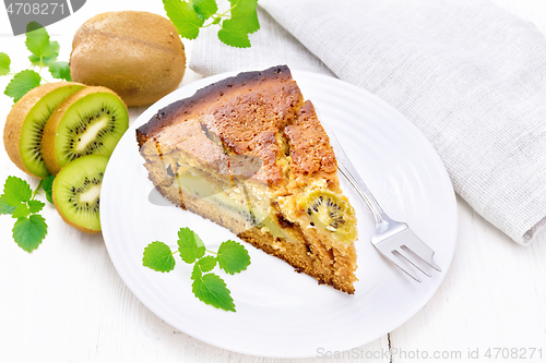 Image of Pie with kiwi in plate on wooden board