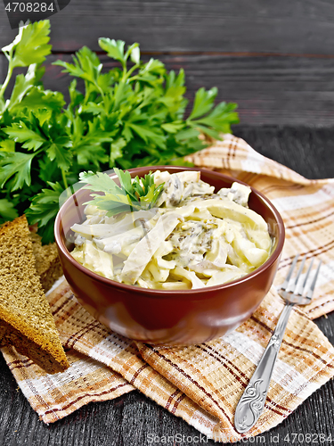 Image of Salad with squid and champignons in bowl on table