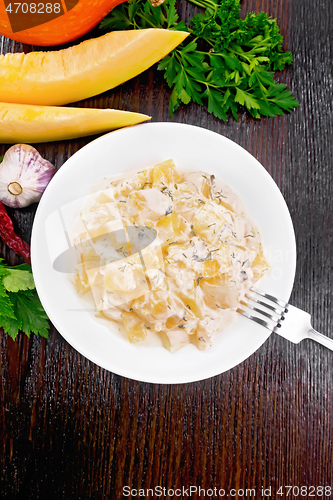 Image of Pumpkin with sour cream sauce in plate on wooden table top