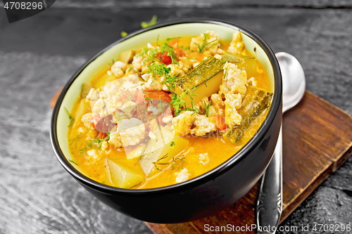 Image of Ragout of zucchini and minced meat in bowl on dark board