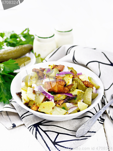 Image of Salad potato with bacon and cucumber in plate on light board