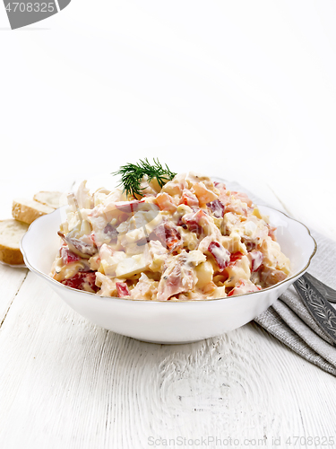 Image of Salad with chicken and vegetables in plate on white wooden board