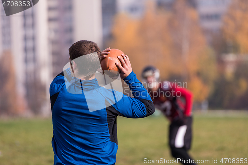 Image of american football team with coach in action