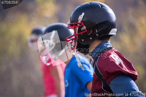 Image of american football team with coach in action