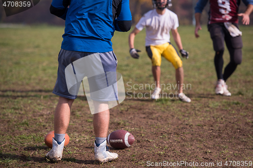 Image of american football team with coach in action