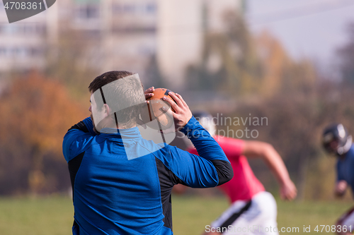 Image of american football team with coach in action