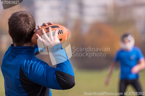 Image of american football team with coach in action