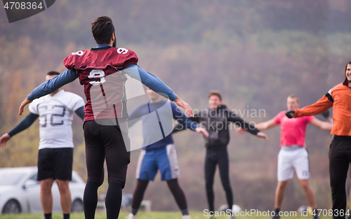 Image of american football players stretching and warming up