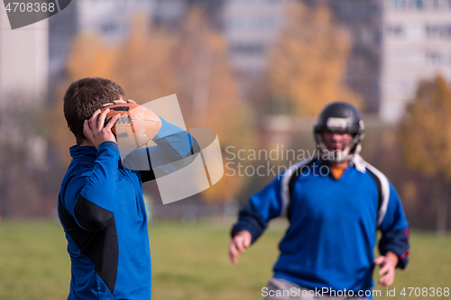 Image of american football team with coach in action