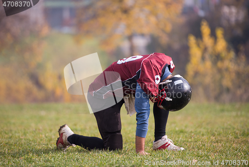 Image of american football player resting after hard training