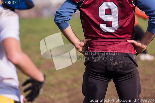 Image of american football team with coach in action