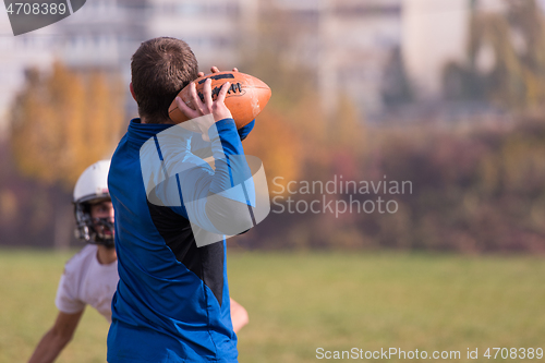 Image of american football team with coach in action