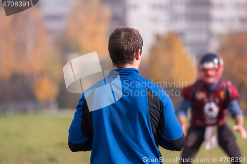 Image of american football team with coach in action