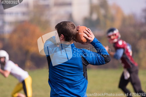 Image of american football team with coach in action