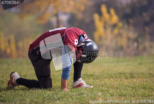 Image of american football player resting after hard training