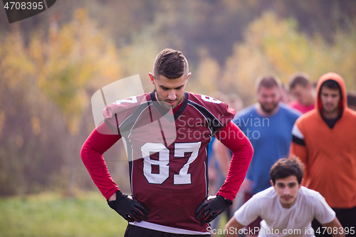 Image of american football players stretching and warming up