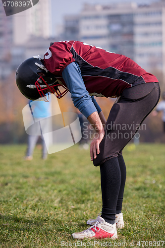 Image of american football player resting after hard training