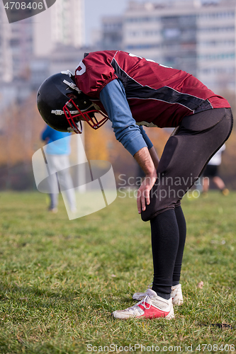 Image of american football player resting after hard training