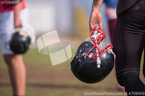 Image of American football player holding helmet