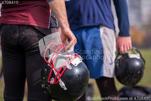 Image of American football player holding helmet