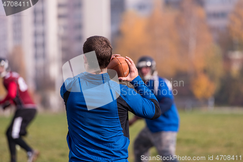 Image of american football team with coach in action