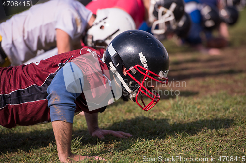 Image of american football team doing push ups