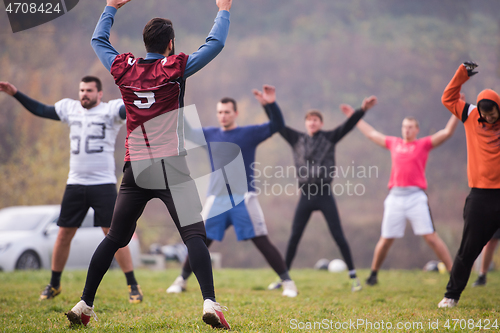 Image of american football players stretching and warming up