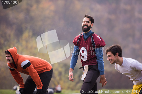 Image of american football players stretching and warming up