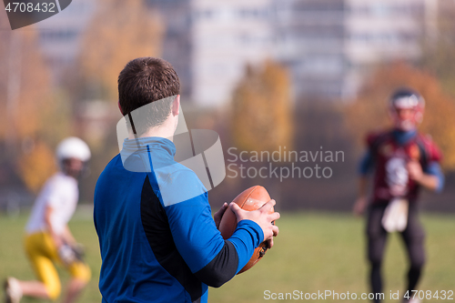 Image of american football team with coach in action