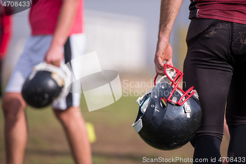 Image of American football player holding helmet