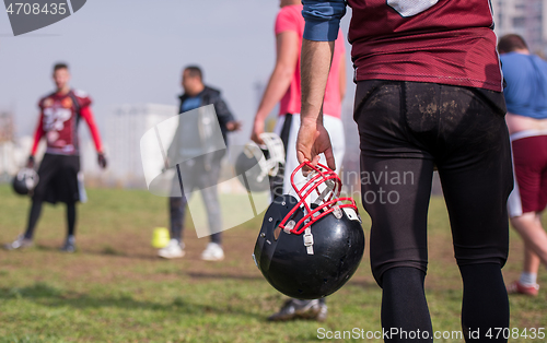 Image of American football player holding helmet