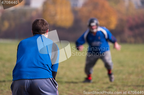 Image of american football team with coach in action