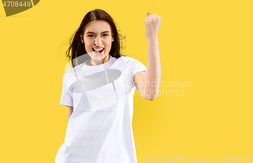 Image of Portrait of beautiful woman isolated on yellow studio background