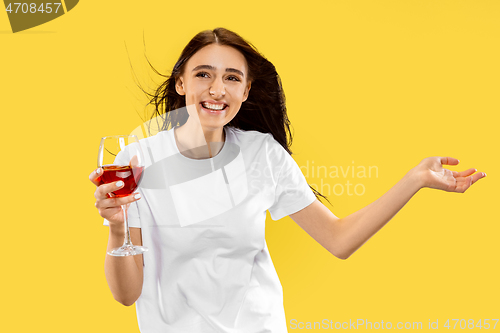 Image of Portrait of beautiful woman isolated on yellow studio background