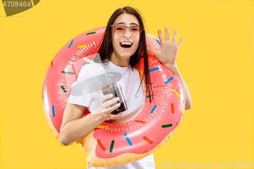 Image of Portrait of beautiful woman isolated on yellow studio background