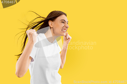 Image of Portrait of beautiful woman isolated on yellow studio background