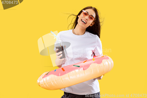 Image of Portrait of beautiful woman isolated on yellow studio background