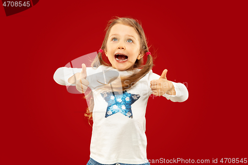 Image of Beautiful emotional little girl isolated on red background