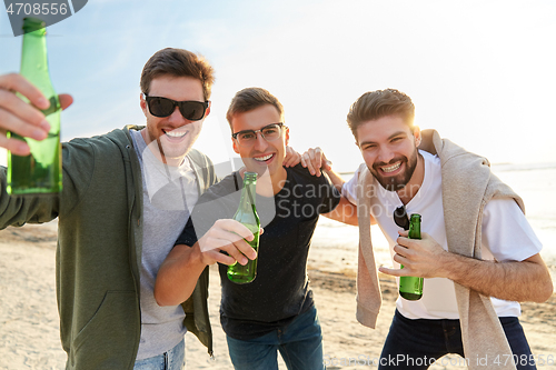 Image of young men toasting non alcoholic beer on beach