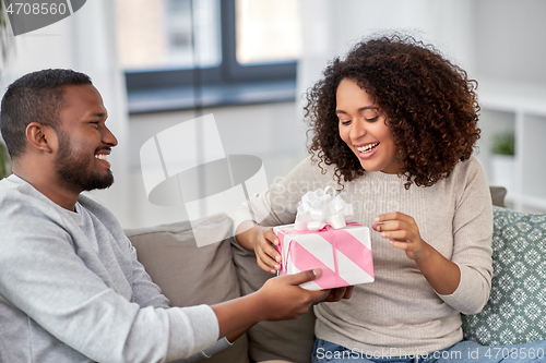 Image of happy couple with gift at home