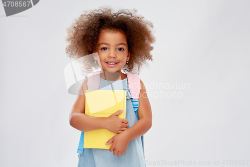Image of happy little african girl with book and backpack