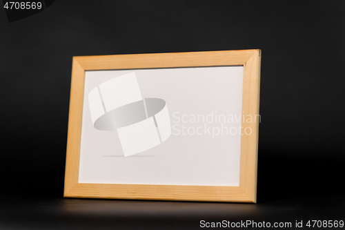 Image of white board in wooden frame on black background