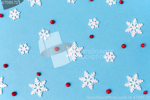 Image of white snowflakes and berries on blue background