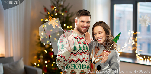 Image of couple with christmas party props in ugly sweaters