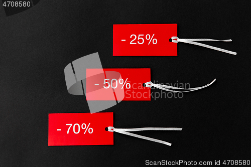 Image of red tags with discount signs on black background