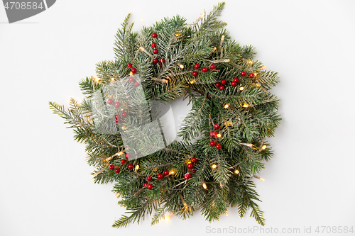 Image of christmas fir wreath with berries and lights