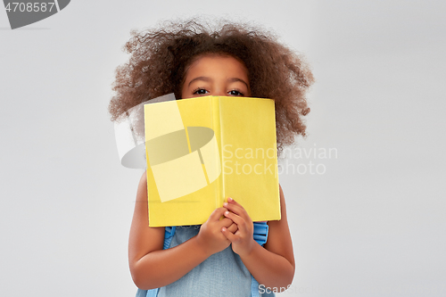 Image of happy little african girl with book