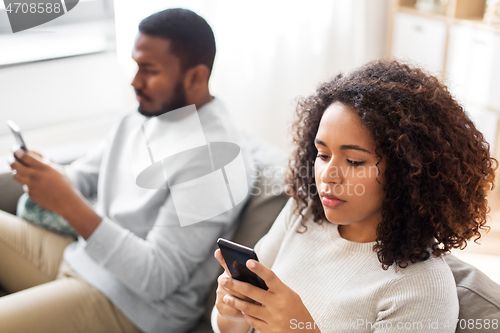 Image of african american couple with smartphone at home