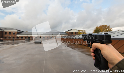 Image of POV of male hands shooting with semi-automatic gun