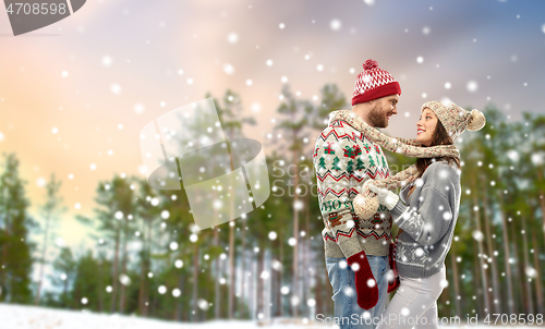 Image of happy couple in ugly christmas sweaters in winter